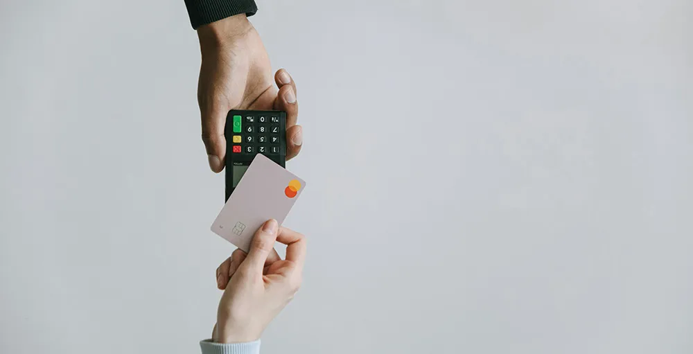 person holding credit card to card reader