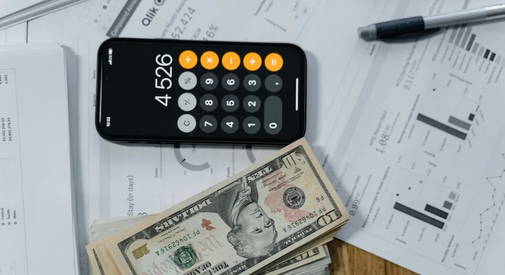 cash money and a calculator on white paper printout