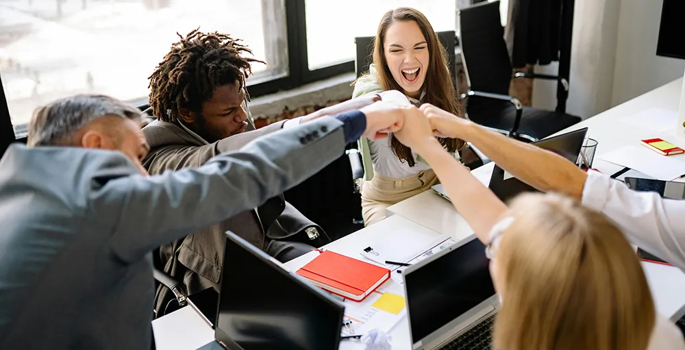 happy employees celebrating with fist bump