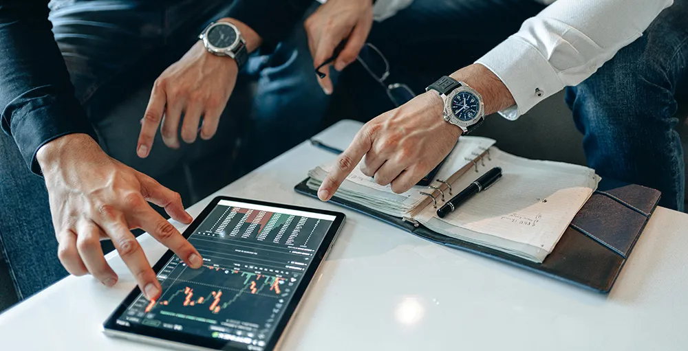 men looking at market on ipad