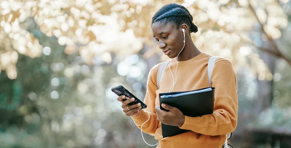 college student using smartphone in park