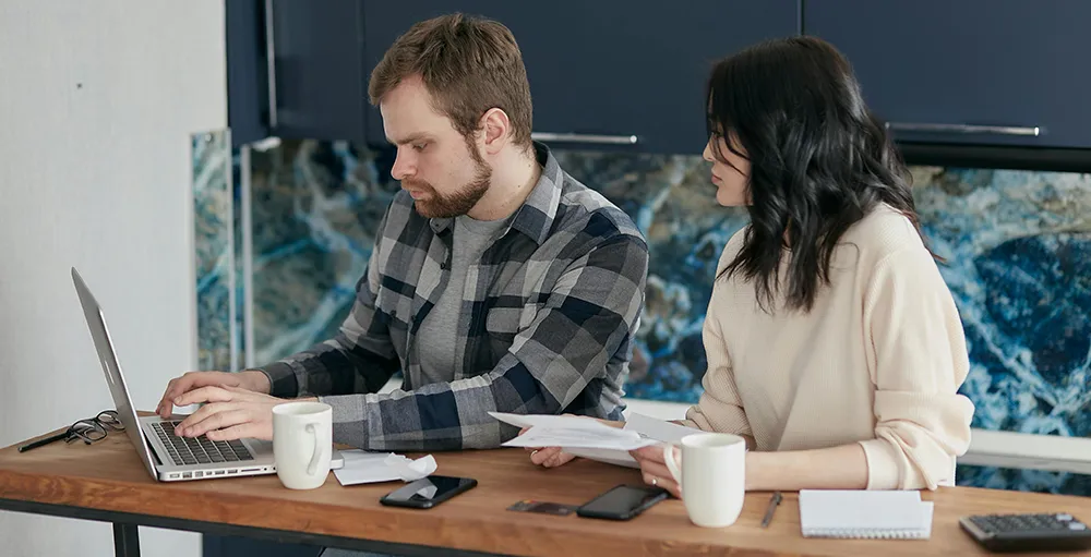 couple budgeting in home kitchen