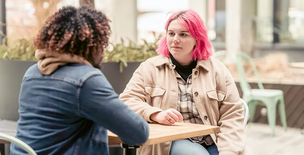 young gen z adults sitting at coffee table