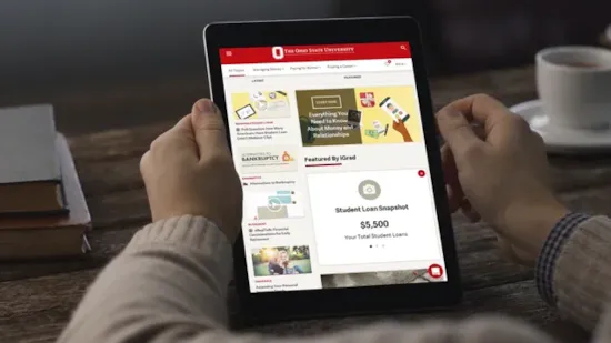 Person holding a tablet displaying an educational website with student loan information and various resources.
