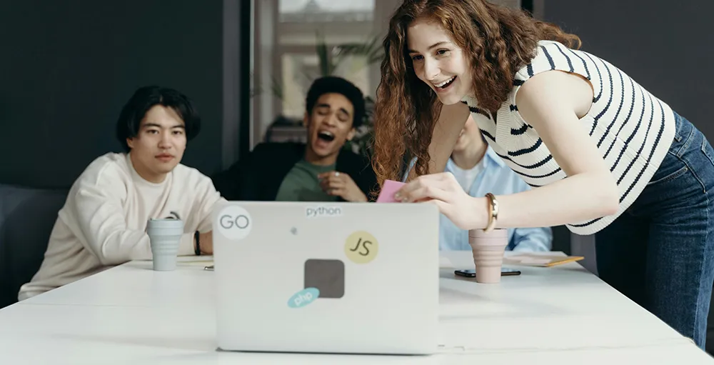 employees laughing looking at laptop