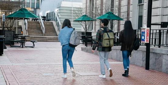 college students walking on sidewalk