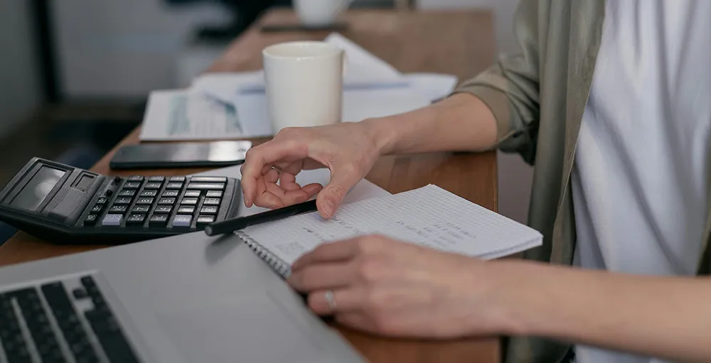 person working on their budget on table