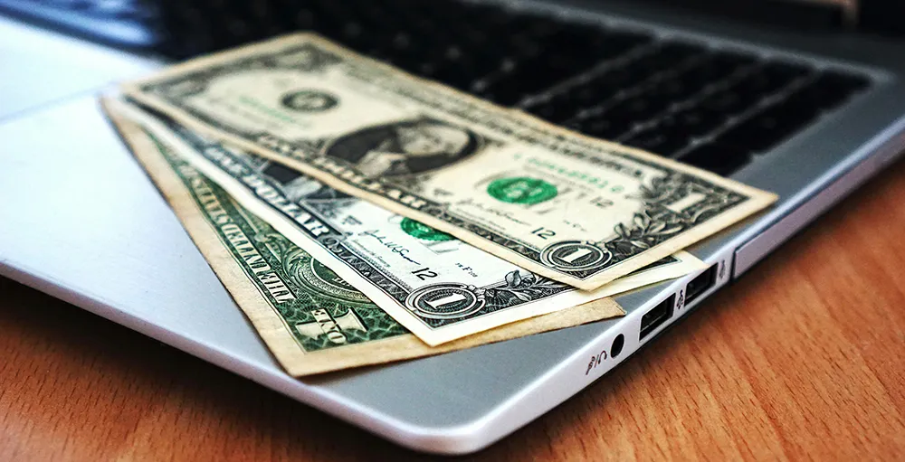 dollar bills on laptop