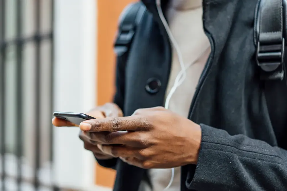 man in coat using smartphone