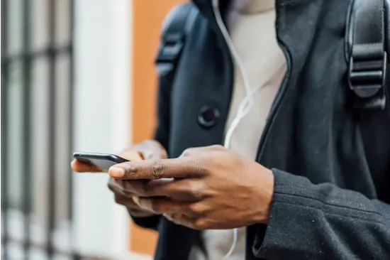 man in coat using smartphone