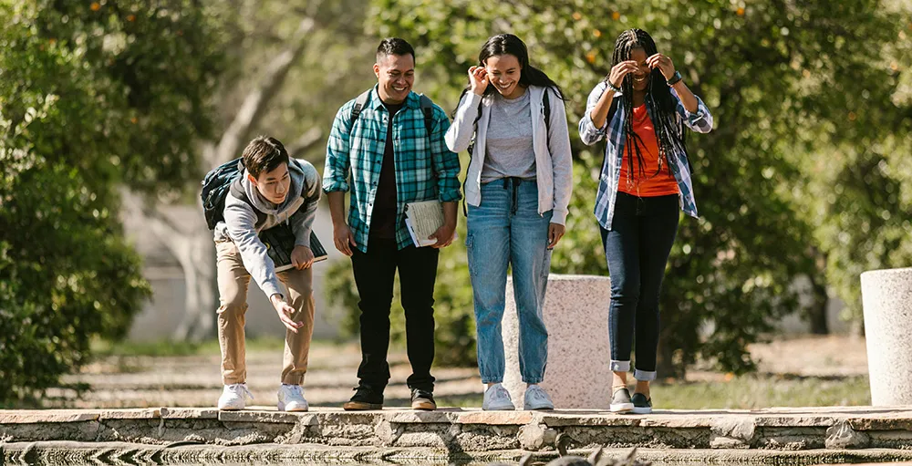 college students standing near water