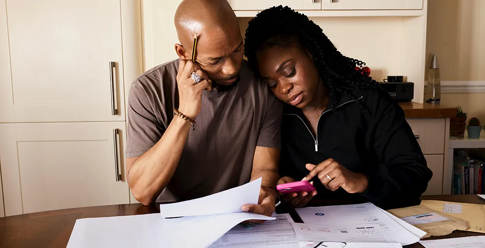 couple sitting by table calculating expenses