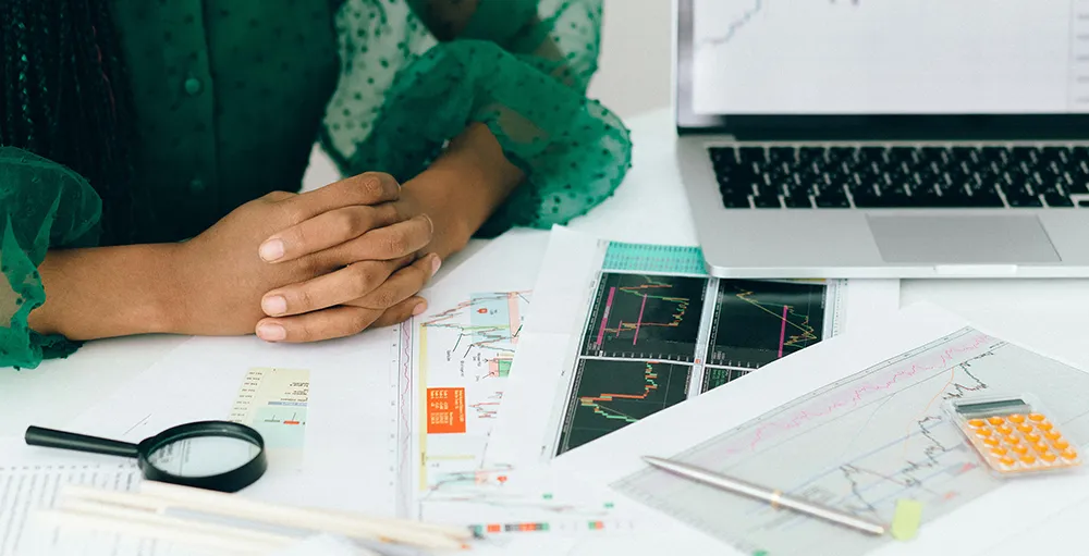 person working with spreadsheets and reports on desk