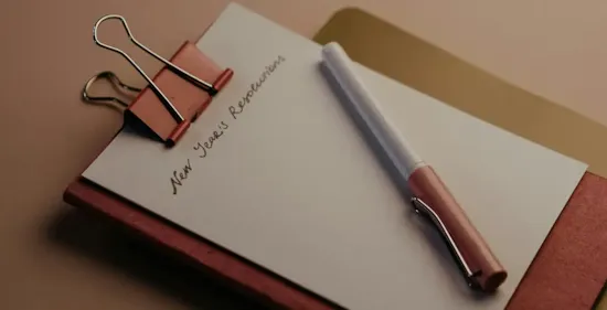 red notebook on table with resolutions list